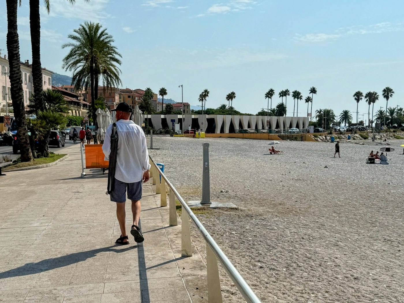 Paseo marítimo con palmeras y el mar al fondo en un día despejado.