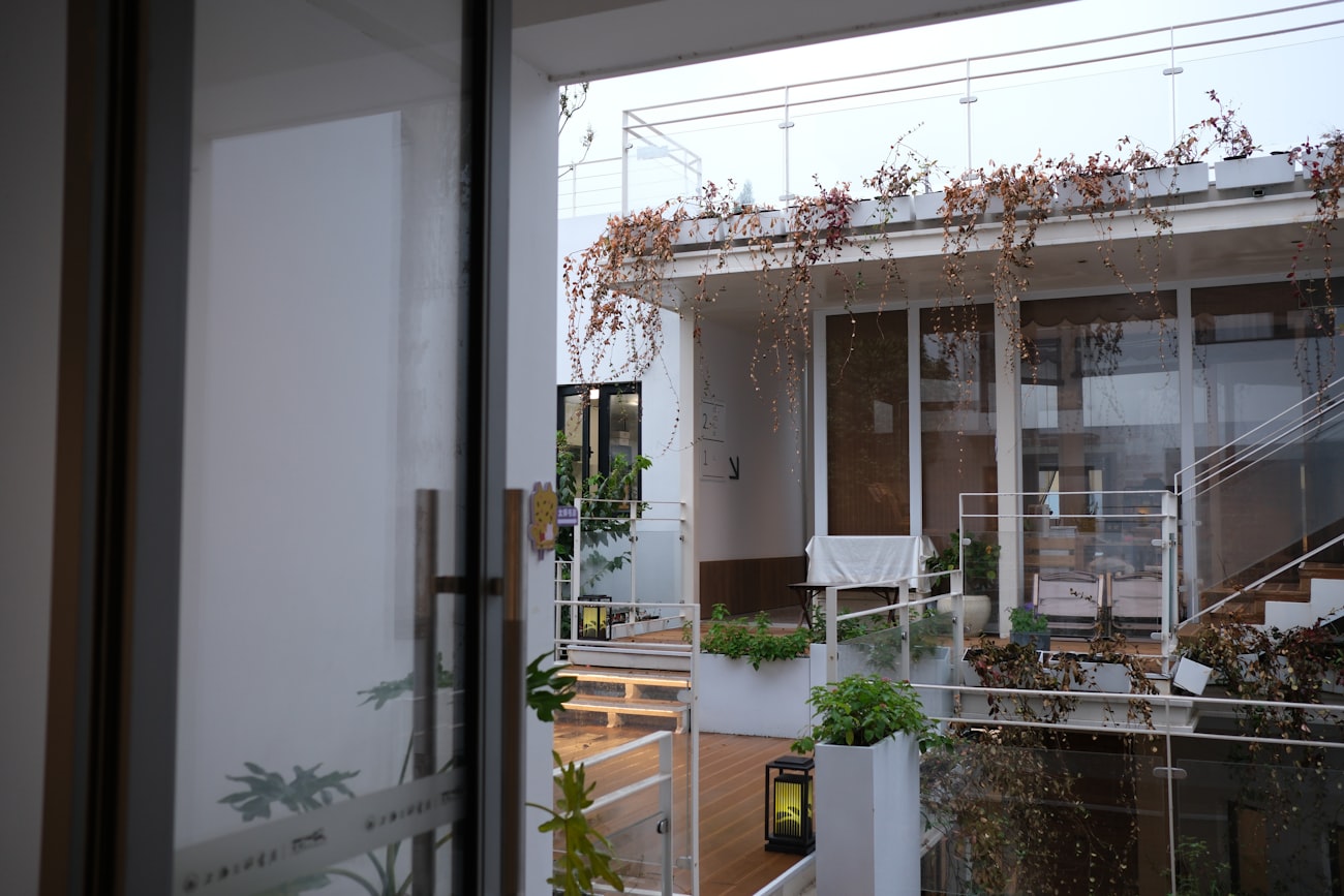 Fachada de un edificio con terrazas plantadas y vegetación colgante.